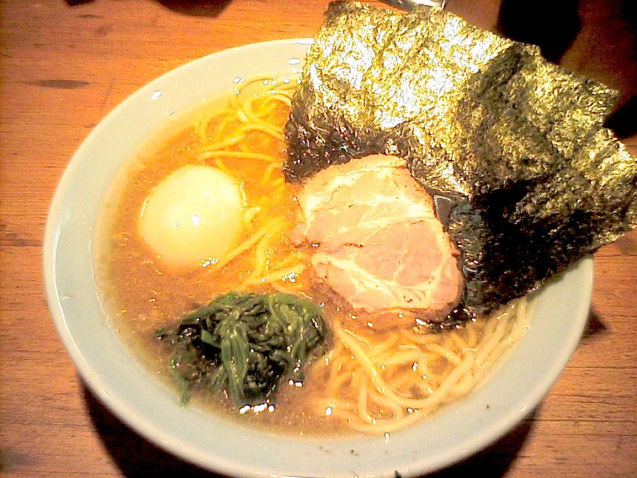 A bowl of iekei ramen with thick noodles, pork, and nori in shoyu-tonkotsu broth